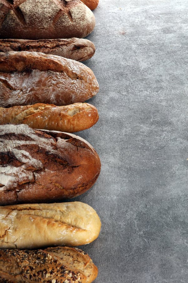 Assortment of Baked Bread and Bread Rolls on Stone Table Background