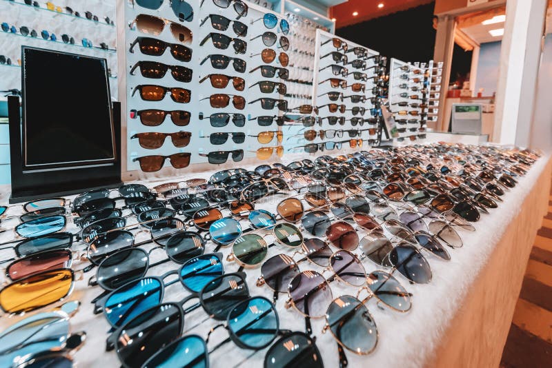 An assortment of fashionable sunglasses of different colors and styles are put up for sale on the store counter. Different color styles stock images, royalty-free photos and pictures