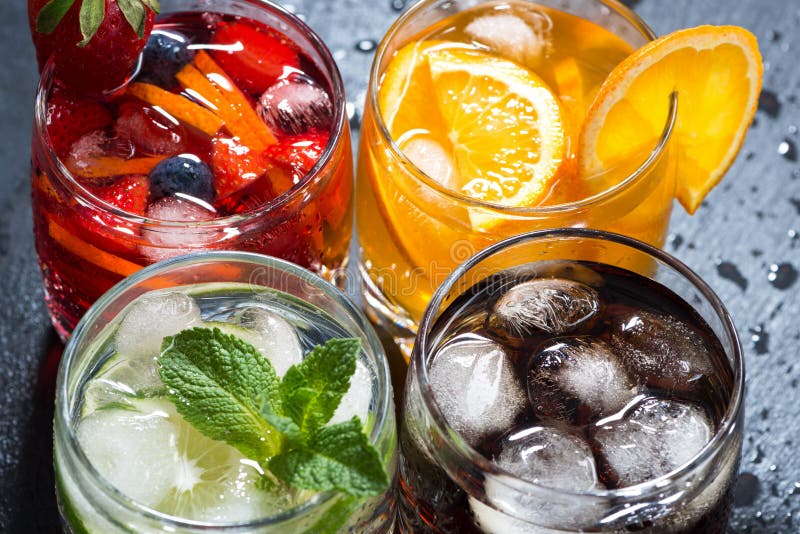 Assortment of fresh iced fruit drinks on a dark background