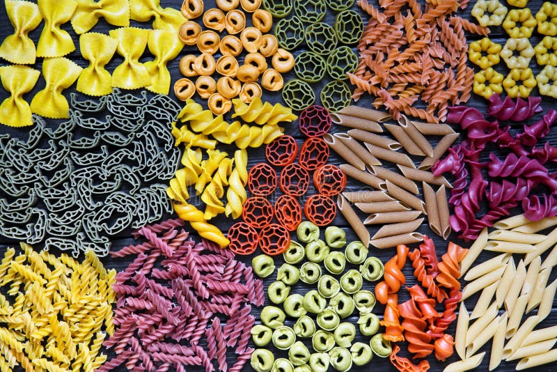 Assortment of pasta. Different kinds of macaroni. Colorful, red, green, yellow, purple, pink noodle. Italian cuisine, food