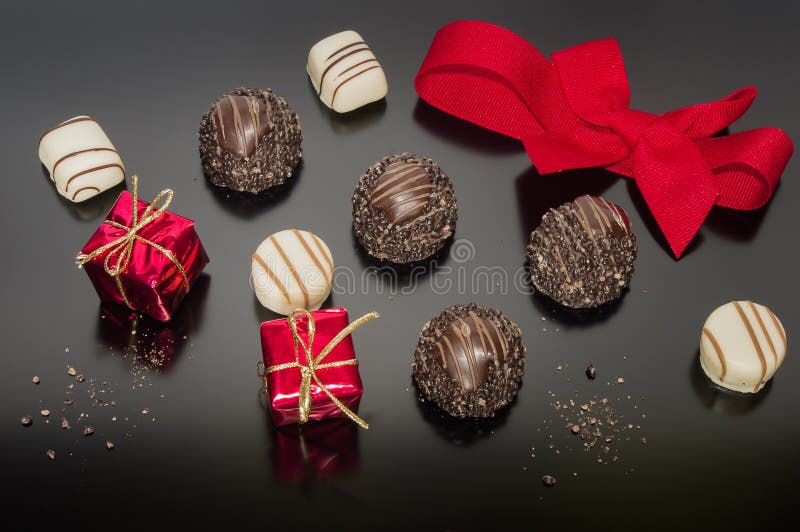 Assortment sweet confectionery chocolate. Candies and pralines set up for Christmas table with red tied ribbon. Square box, gift