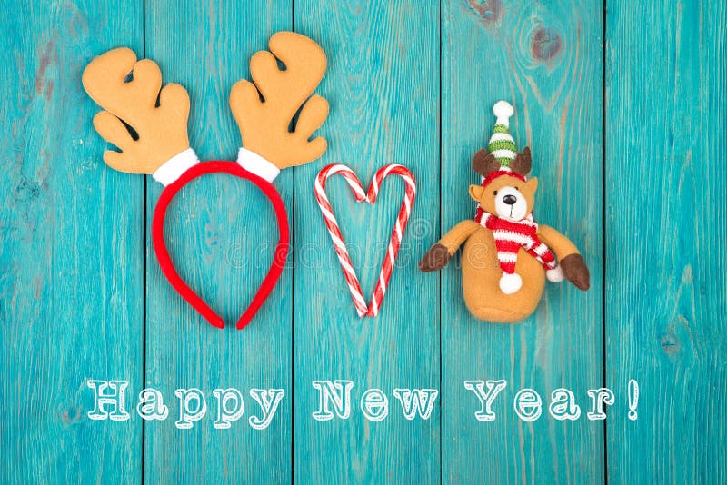 Astas del reno del juguete y oso de peluche, caramelo y texto ' Feliz Año Nuevo imágenes de archivo libres de regalías Astas del reno del juguete y oso de peluche, caramelo y texto ' Feliz Año Nuevo imágenes de archivo libres de regalías