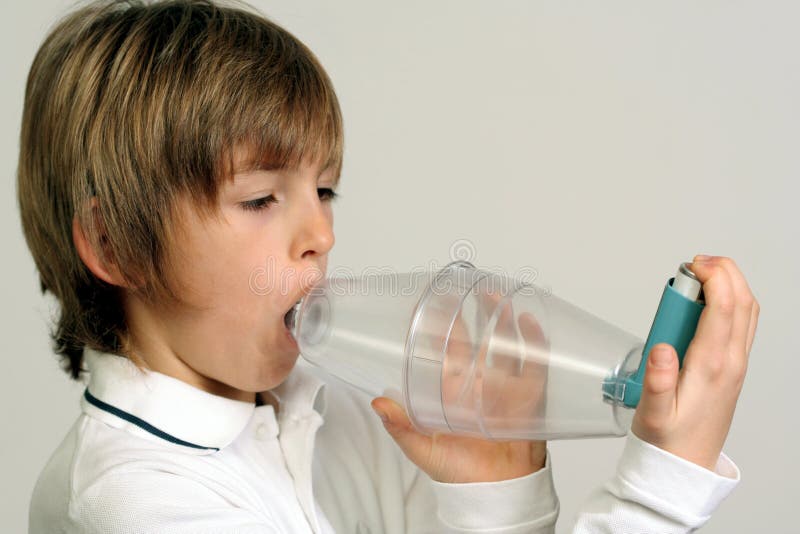 Bambino, utilizzando distanziatore in plastica per l'inalazione di medicina asma.
