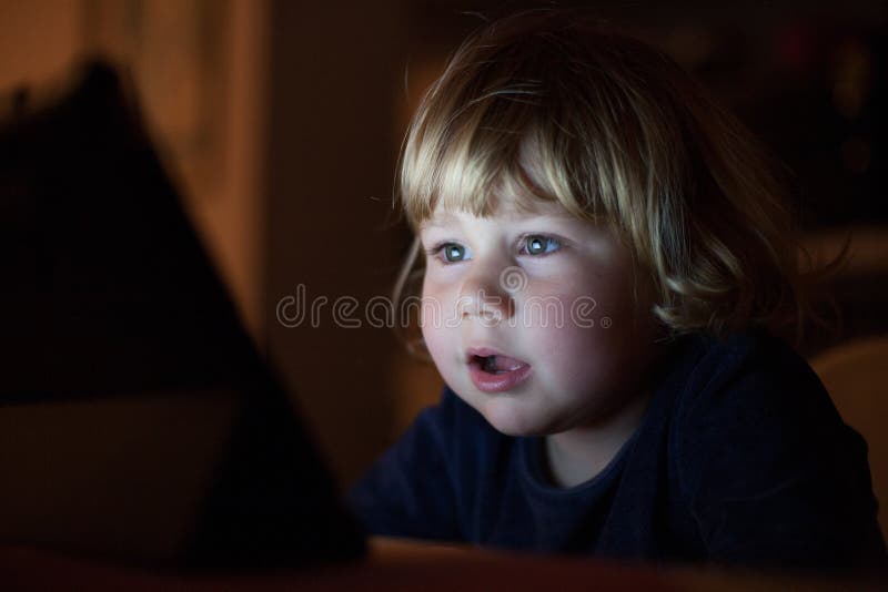 Astonished baby face watching screen at night royalty free stock image Astonished baby face watching screen at night royalty free stock image