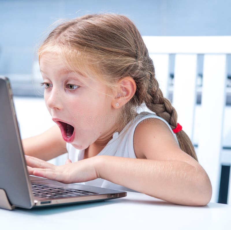 Astonished little girl with her computer