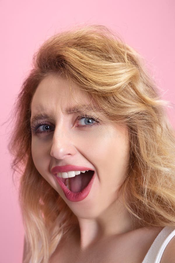 Caucasian young woman`s portrait isolated on pink studio background. Beautiful female model. Concept of human emotions