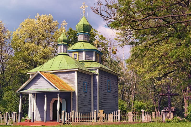 Astonishing landscape view of ancient wooden cossack church with small cemetery in forest. Few minutes before spring thunderstorm stock photography Astonishing landscape view of ancient wooden cossack church with small cemetery in forest. Few minutes before spring thunderstorm stock photography