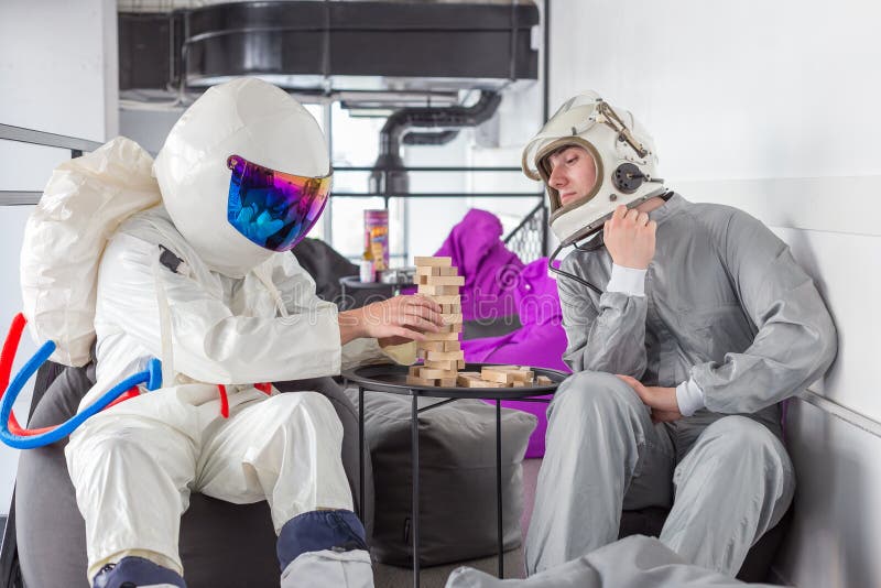 Astronautas jogando xadrez em trajes espaciais em hotel cápsula