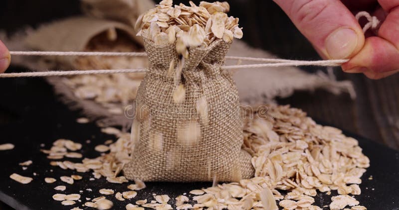 Atar una bolsa de lino gruesa con gotas de avena almacen de video