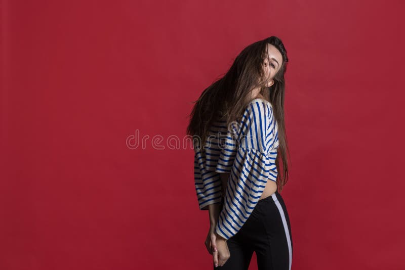 Atelieraufnahme einer reizenden Schönheit lokalisiert gegen eine leere rote Studiowand lizenzfreie stockfotos Atelieraufnahme einer reizenden Schönheit lokalisiert gegen eine leere rote Studiowand lizenzfreie stockfotos