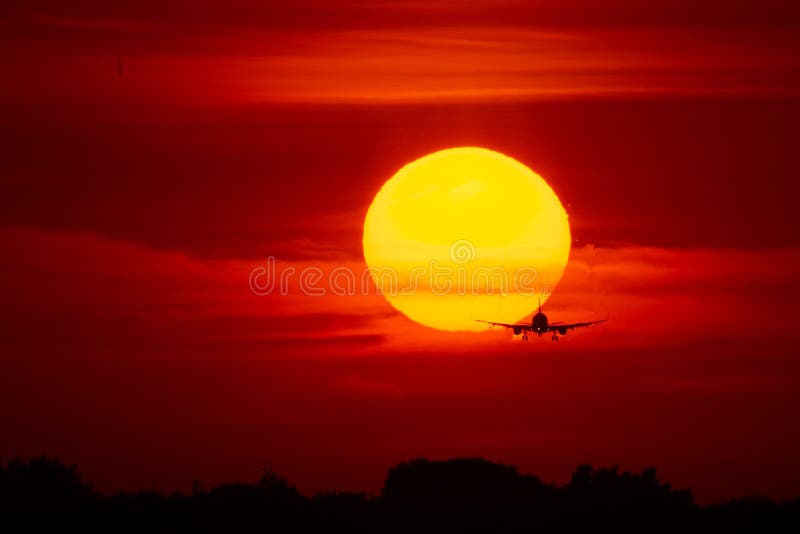 Aterrissagem ou decolagem de avião no por do sol com o céu vermelho no aeroporto internacional de Bucareste, mancha lisa fotografia de stock Aterrissagem ou decolagem de avião no por do sol com o céu vermelho no aeroporto internacional de Bucareste, mancha lisa fotografia de stock