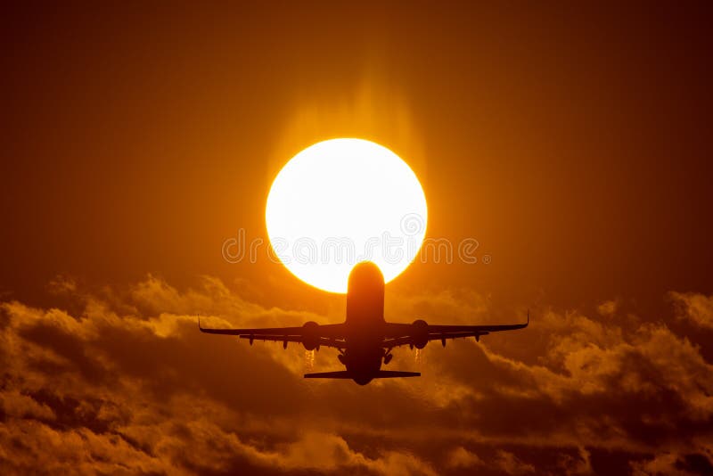 Aterrissagem ou decolagem de avião no por do sol com o céu vermelho no aeroporto internacional de Bucareste, mancha lisa imagens de stock Aterrissagem ou decolagem de avião no por do sol com o céu vermelho no aeroporto internacional de Bucareste, mancha lisa imagens de stock