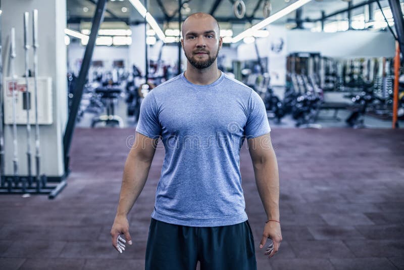 Athl?te moderne Jeune homme beau dans l'habillement de sports regardant la caméra tout en se tenant sur le gymnase photo stock Athl?te moderne Jeune homme beau dans l'habillement de sports regardant la caméra tout en se tenant sur le gymnase photo stock