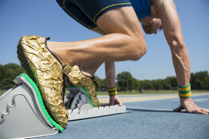 Athlet in den Goldschuhen auf Startblöcken stockbild Athlet in den Goldschuhen auf Startblöcken stockbild