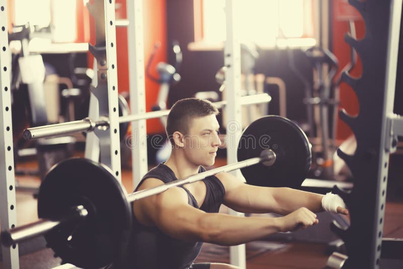 Athlet macht eine Hocke mit einem Barbell lizenzfreie stockfotografie Athlet macht eine Hocke mit einem Barbell lizenzfreie stockfotografie