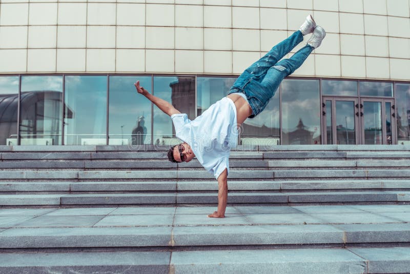 Athlete Guy Dancer In White T-shirt, Jeans, Jumped On One Arm, In ...