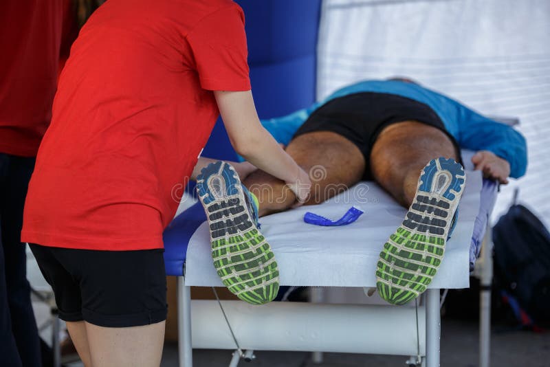 Athlete Lying on a Bed while Having Legs Massaged after a Physical