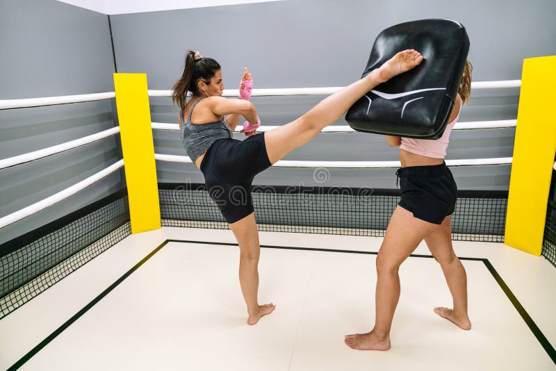 Athlete Practicing High Kick with Her Partner in the Ring at a
