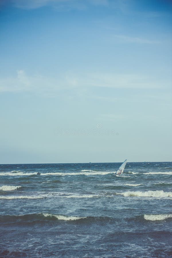 Athlete rides a sailing board at sea in a storm stock images Athlete rides a sailing board at sea in a storm stock images