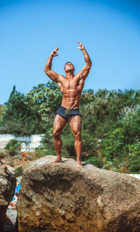 Athlete stands on a rock by the sea