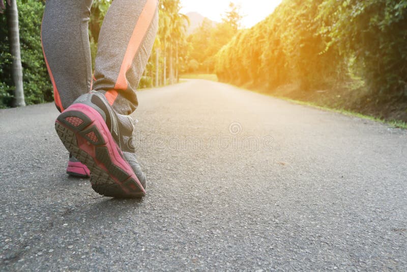 Athlete woman`s feet with running shoe walking in public park.female active lifestyle for future competition concept