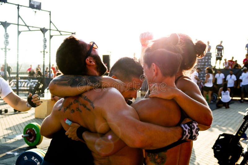 Team of athletes embracing in a circle celebrating a victory at a CrossFit event. Candid photo. Teamwork and victory concept. Team of athletes embracing in a circle celebrating a victory at a CrossFit event. Candid photo. Teamwork and victory concept