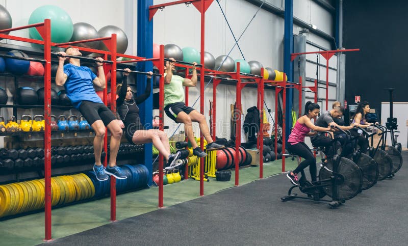 Athletes Doing Pull Ups and Air Bike in the Gym Stock Image - Image of ...