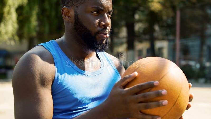 Athletic African-American basketball player holding ball, preparing for game royalty free stock images Athletic African-American basketball player holding ball, preparing for game royalty free stock images