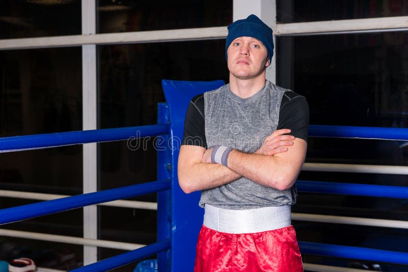 Athletic Boxer with Arms Across Standing in a Regular Boxing Ring Stock