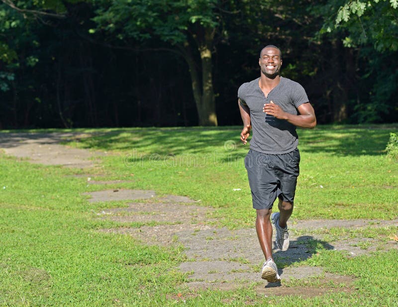 Sporty man jogging in a park stock photo