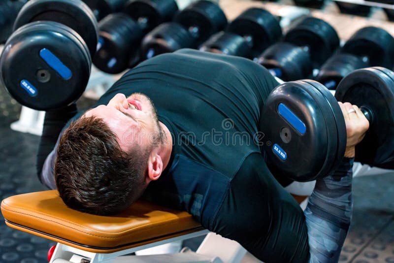 Muscular Bodybuilder Bench Press Workout in Modern Gym Stock Photo