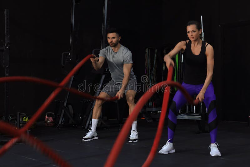 Athletic Young Couple With Battle Rope Doing Exercise In Functional