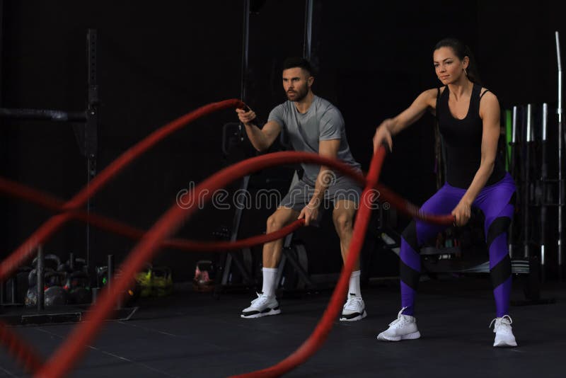 Athletic Young Couple With Battle Rope Doing Exercise In Functional