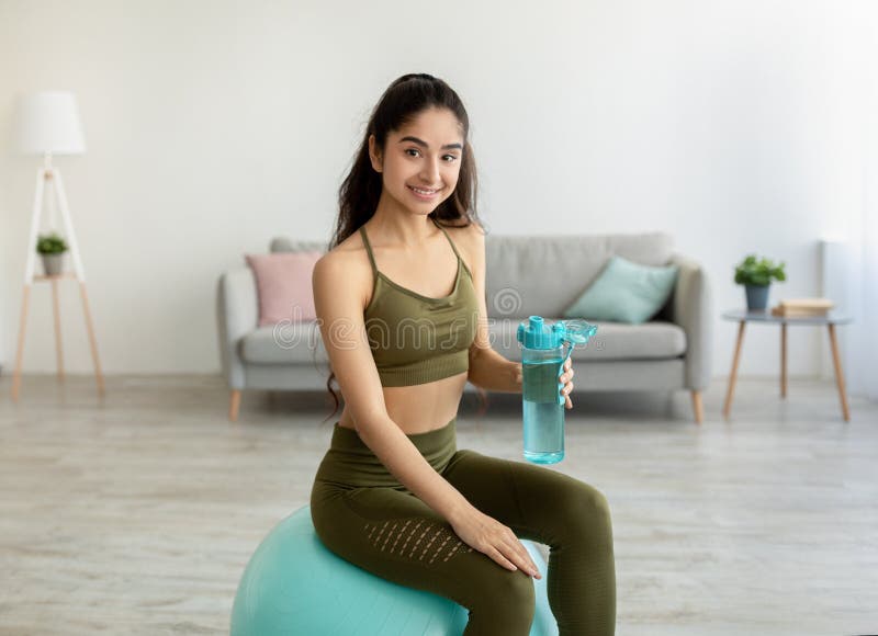 https://thumbs.dreamstime.com/b/athletic-young-indian-woman-holding-bottle-water-sitting-fitness-ball-home-beautiful-eastern-female-staying-232476919.jpg