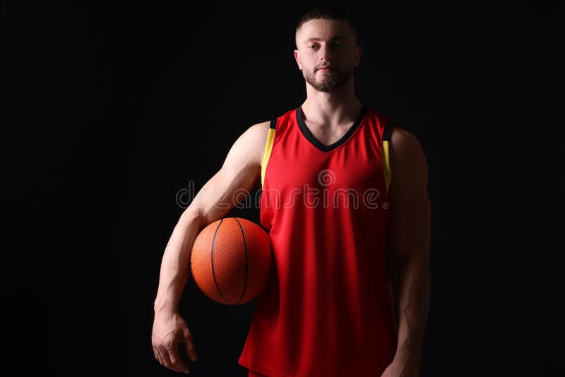 Athletic Young Man with Basketball Ball on Black Background Stock Photo