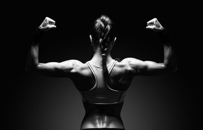 Athletic young woman showing muscles of the back