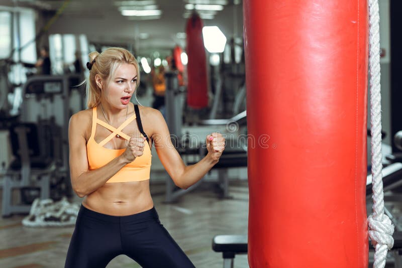 Athletic young woman training with punching bag at gym royalty free stock photos Athletic young woman training with punching bag at gym royalty free stock photos