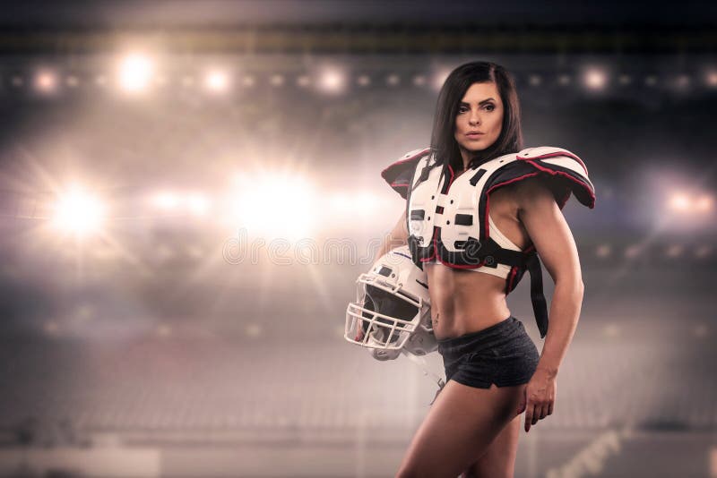 Athletische Frau gekleidet als amerikanischer Fußball-Spieler Reale Uniform, Sturzhelm, Auflagen, Kugel lizenzfreie stockfotografie Athletische Frau gekleidet als amerikanischer Fußball-Spieler Reale Uniform, Sturzhelm, Auflagen, Kugel lizenzfreie stockfotografie