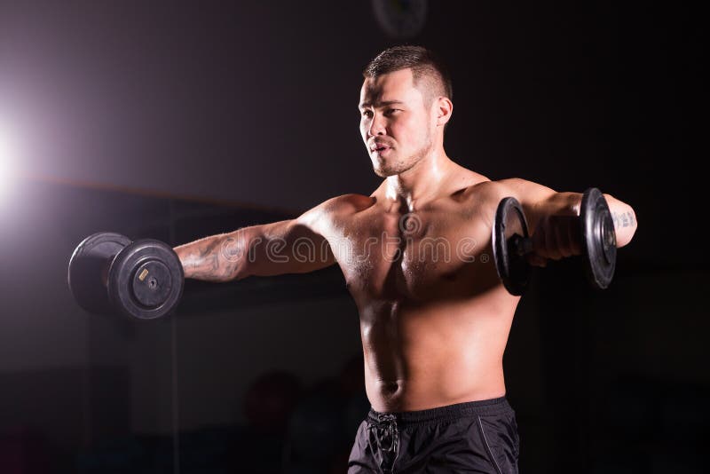 Athletischer Mann der hübschen Energie mit Dummkopf Starker Bodybuilder mit sechs Satz, perfekter ABS, Schultern, Bizeps, Trizeps lizenzfreie stockfotos Athletischer Mann der hübschen Energie mit Dummkopf Starker Bodybuilder mit sechs Satz, perfekter ABS, Schultern, Bizeps, Trizeps lizenzfreie stockfotos