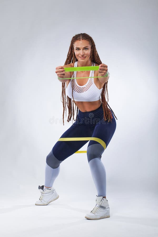 Athlète convenable de femme de sports de jeunes musculaires Séance d'entraînement avec les bandes ou l'extenseur dans le gymnase photo stock Athlète convenable de femme de sports de jeunes musculaires Séance d'entraînement avec les bandes ou l'extenseur dans le gymnase photo stock