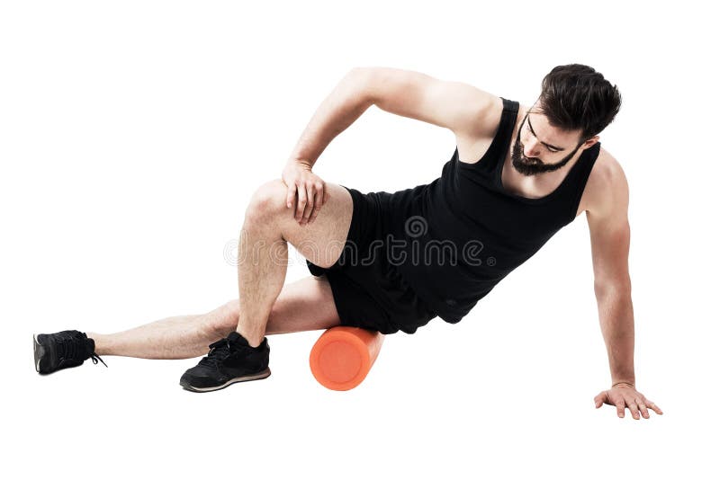 Athlète massant et étirant le muscle iliotibial de bande avec le rouleau de mousse images stock Athlète massant et étirant le muscle iliotibial de bande avec le rouleau de mousse images stock