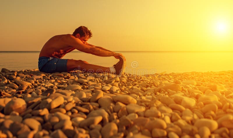 Athlète pratiquant, yoga sur la plage au coucher du soleil images libres de droits Athlète pratiquant, yoga sur la plage au coucher du soleil images libres de droits