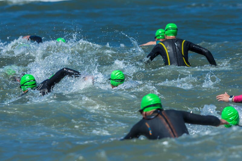 Athlètes de triathlon courant dans la mer pour la jambe de bain images libres de droits Athlètes de triathlon courant dans la mer pour la jambe de bain images libres de droits