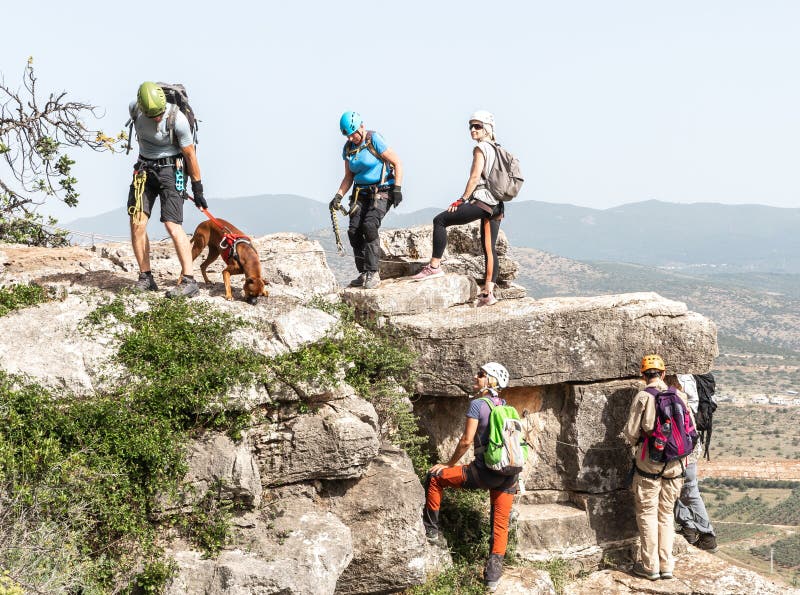 Tiberias, Israel, April 23, 2024 : Professional athletes with special equipment climb Via Ferrata Ravid route with a dog in the mountains near Tiberias in northern Israel. Tiberias, Israel, April 23, 2024 : Professional athletes with special equipment climb Via Ferrata Ravid route with a dog in the mountains near Tiberias in northern Israel