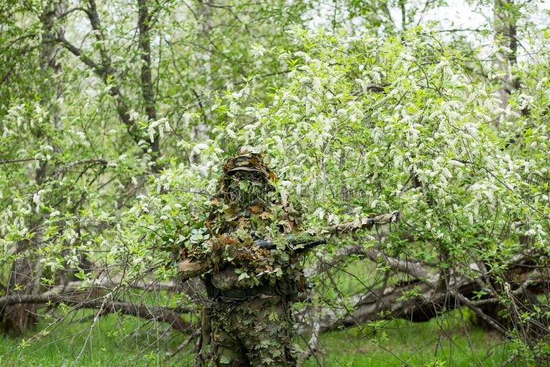 Atirador furtivo camuflado na floresta em emboscada. militar apontando uma  arma, um rifle para o inimigo na natureza. exército, airsoft, hobby,  conceito de jogo