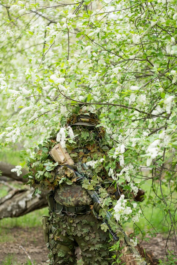 Atirador furtivo camuflado na floresta em emboscada. militar apontando uma  arma, um rifle para o inimigo na natureza. exército, airsoft, hobby,  conceito de jogo