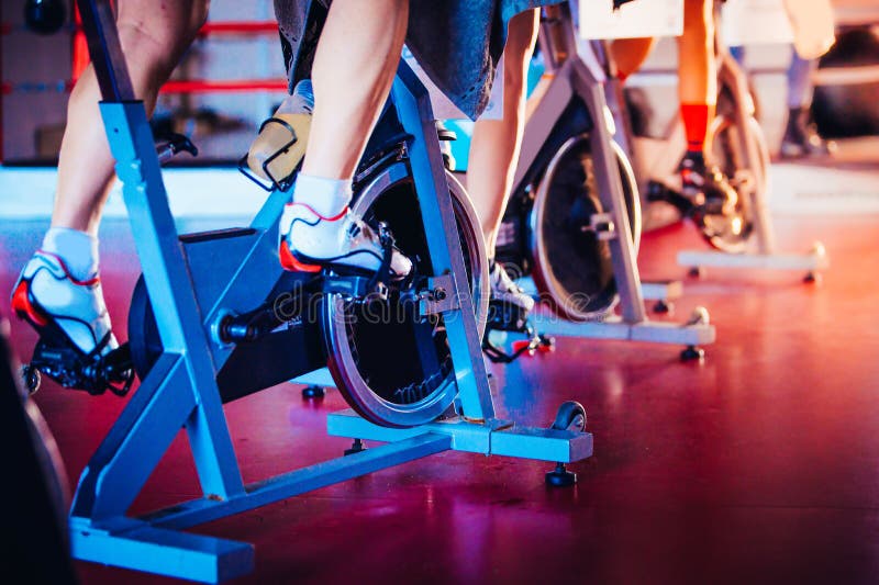 Spinning class, group activity on stationary bike. Team cardio excercise on bicycle. Spinning class, group activity on stationary bike. Team cardio excercise on bicycle..