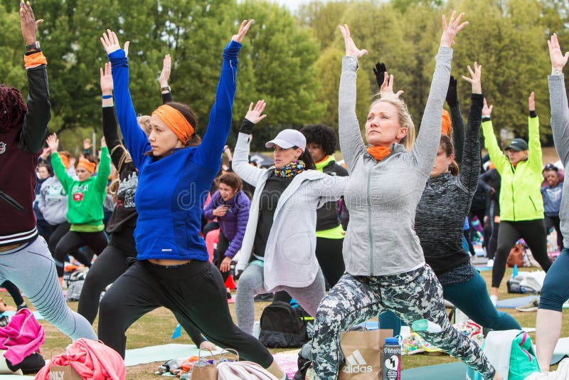 Women Do Warrior Pose At Massive Atlanta Outdoor Yoga Class stock photography Women Do Warrior Pose At Massive Atlanta Outdoor Yoga Class stock photography