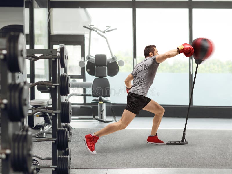 Atleta che colpisce una borsa da boxe in piedi fotografia stock