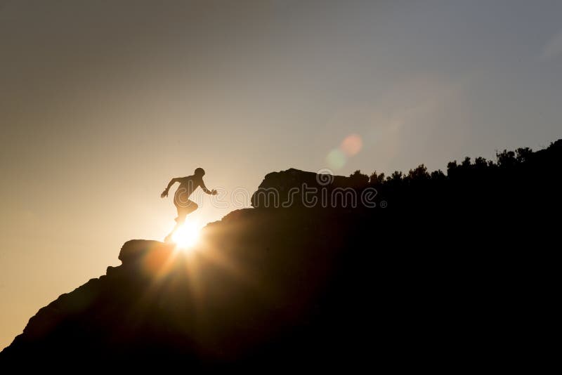 Atleta de corrida da fuga que corre na montanha, no por do sol